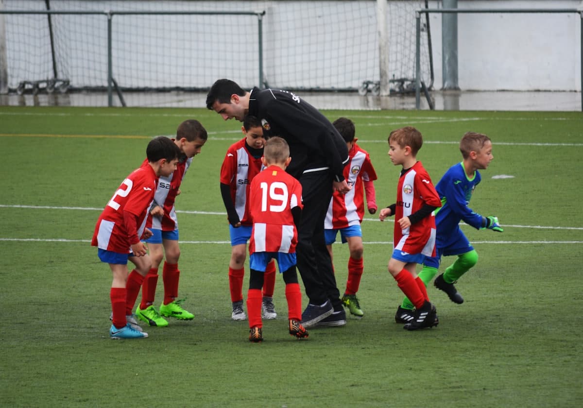 A coach talking to young players during an academy session
