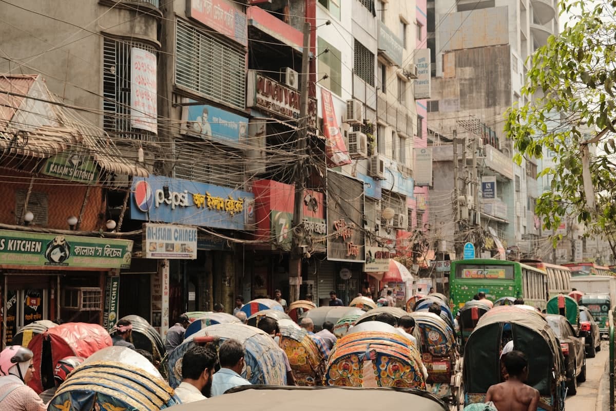 A busy neighbourhood street crowded with rickshaws and shopfronts