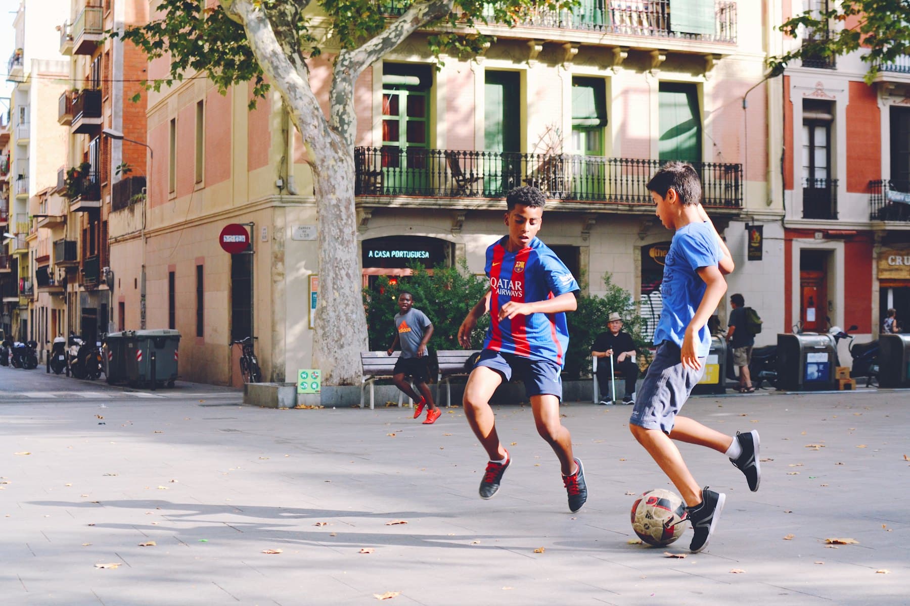 Two boys playing football on a neighbourhood street